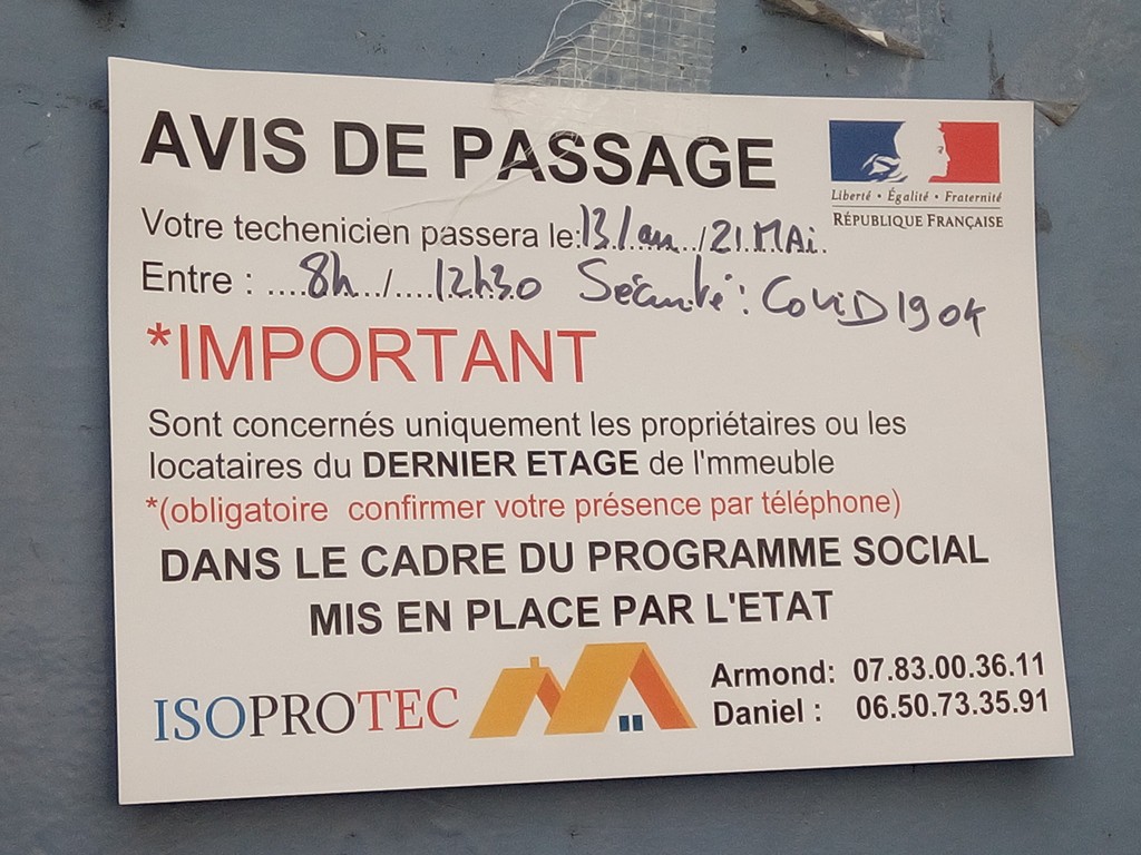 Photo d'un avis de passage apposé sur une porte de couleur gris-bleu.