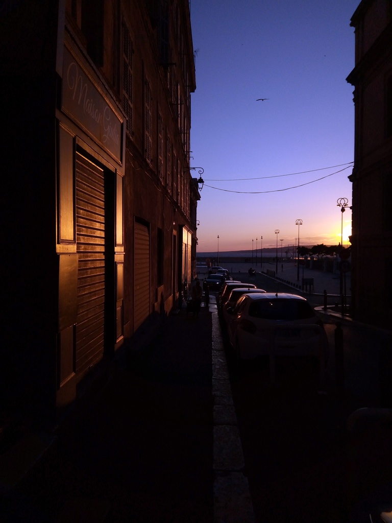 Une rue, des voitures, des bâtisses et surtout un coucher de soleil !
